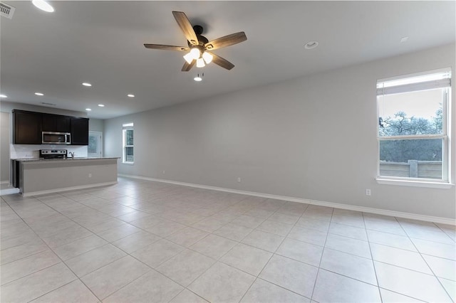 unfurnished living room featuring light tile patterned floors and ceiling fan