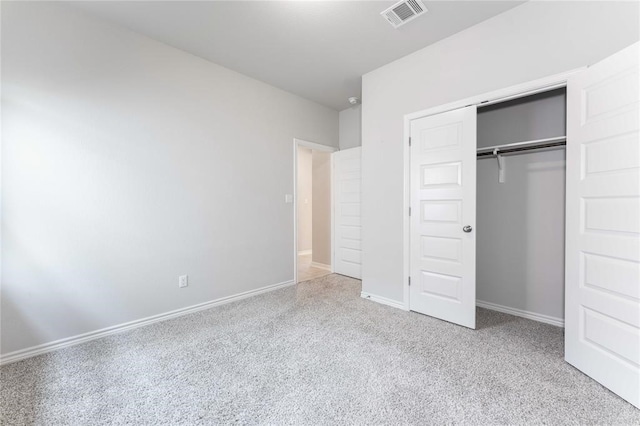 unfurnished bedroom with a closet and light colored carpet