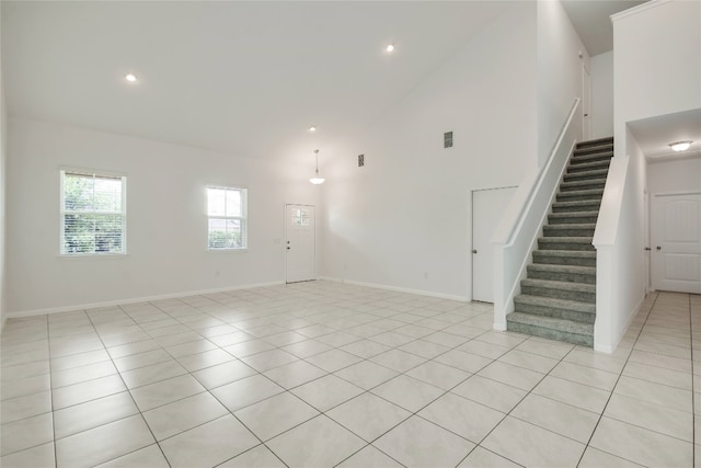 tiled empty room featuring high vaulted ceiling