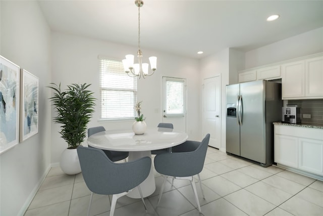 dining room featuring a notable chandelier and light tile patterned flooring