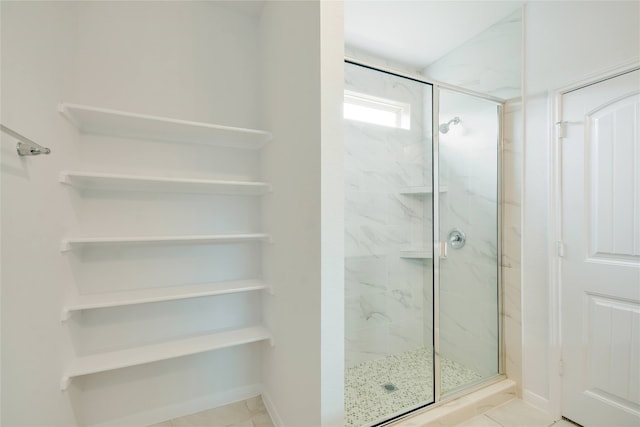 bathroom with tile patterned flooring and a shower with shower door