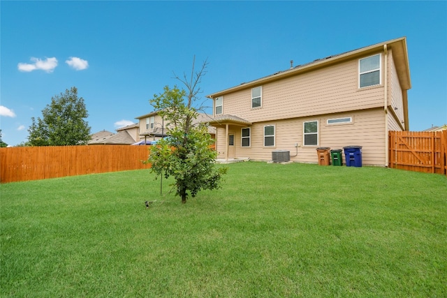 back of property with a yard and central AC unit