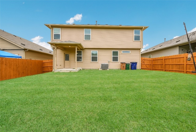 back of property featuring a lawn and central AC