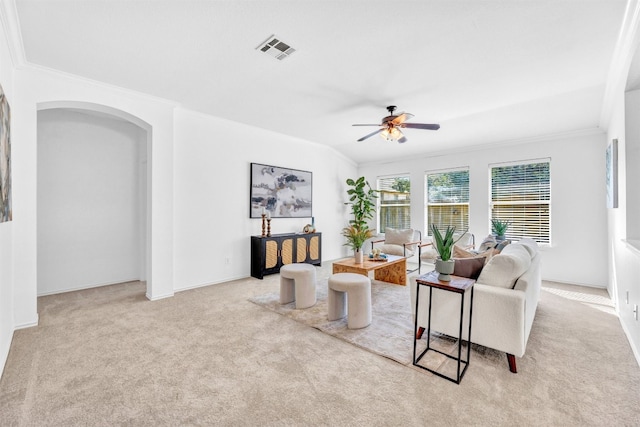 carpeted living room with ceiling fan, crown molding, and vaulted ceiling