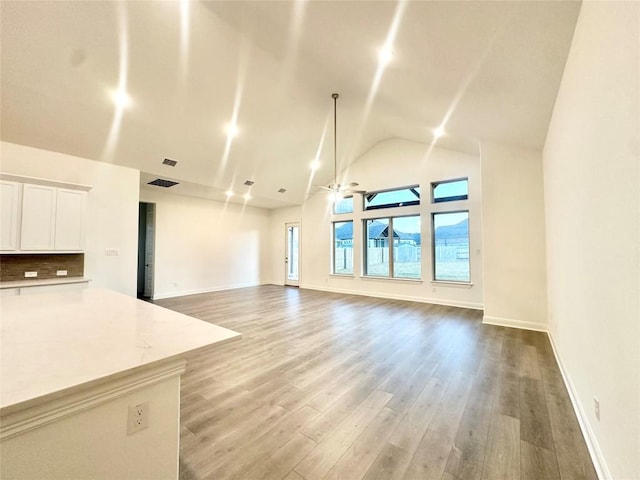 unfurnished living room with hardwood / wood-style flooring, ceiling fan, and lofted ceiling