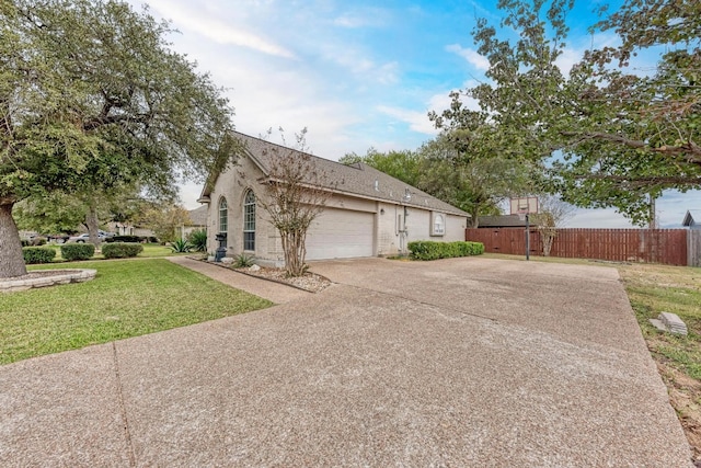 view of side of property featuring a garage and a lawn