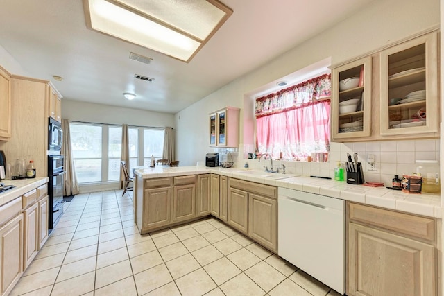 kitchen featuring tasteful backsplash, sink, black appliances, light brown cabinets, and tile countertops