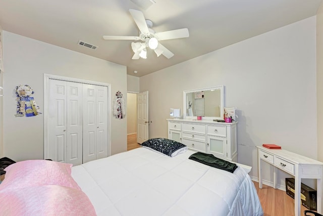 bedroom with ceiling fan, a closet, and light hardwood / wood-style floors