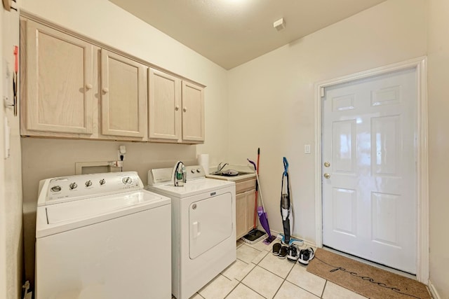 laundry area with light tile patterned flooring, cabinets, and independent washer and dryer