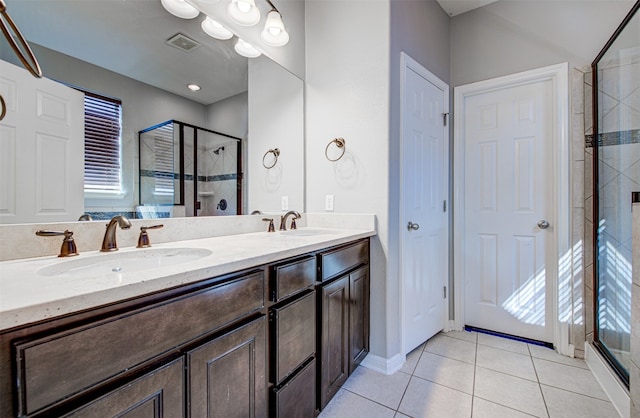 bathroom featuring tile patterned flooring, vanity, and a shower with shower door