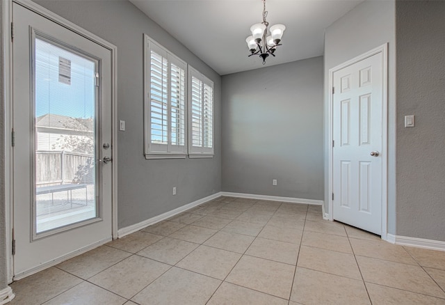 interior space featuring light tile patterned flooring, a healthy amount of sunlight, and a notable chandelier