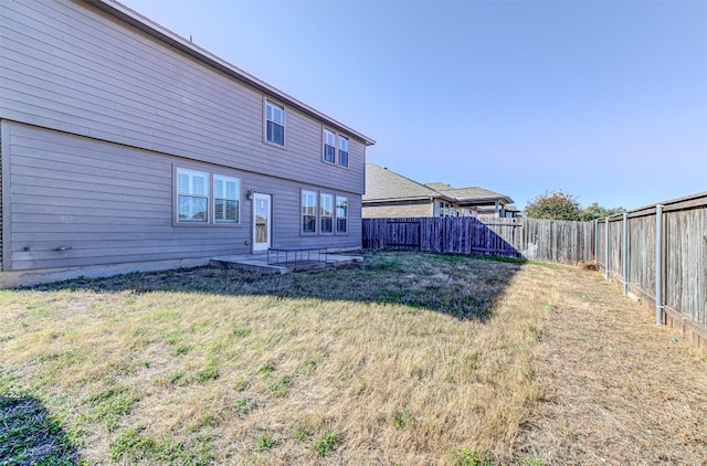 back of property featuring a lawn and a patio area