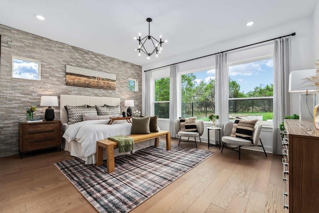 bedroom with hardwood / wood-style floors and an inviting chandelier