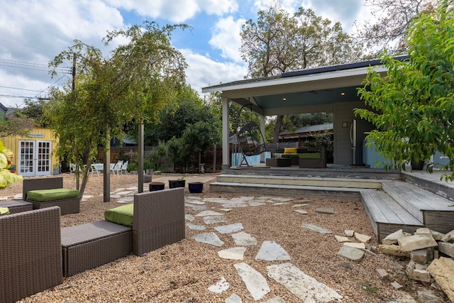 view of patio with an outdoor living space, a wooden deck, and french doors