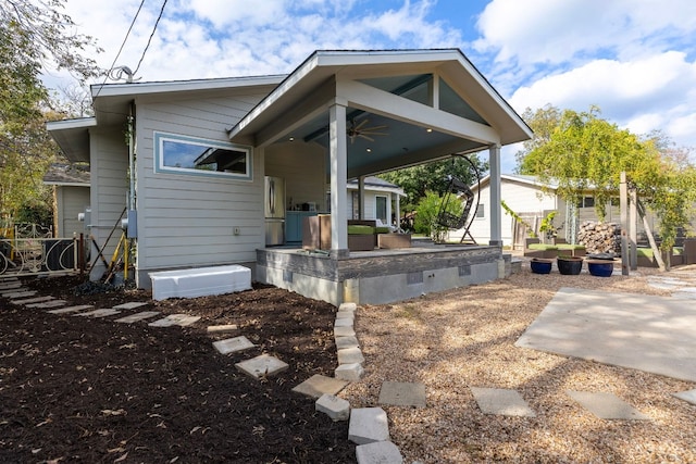 rear view of house with ceiling fan and a patio area