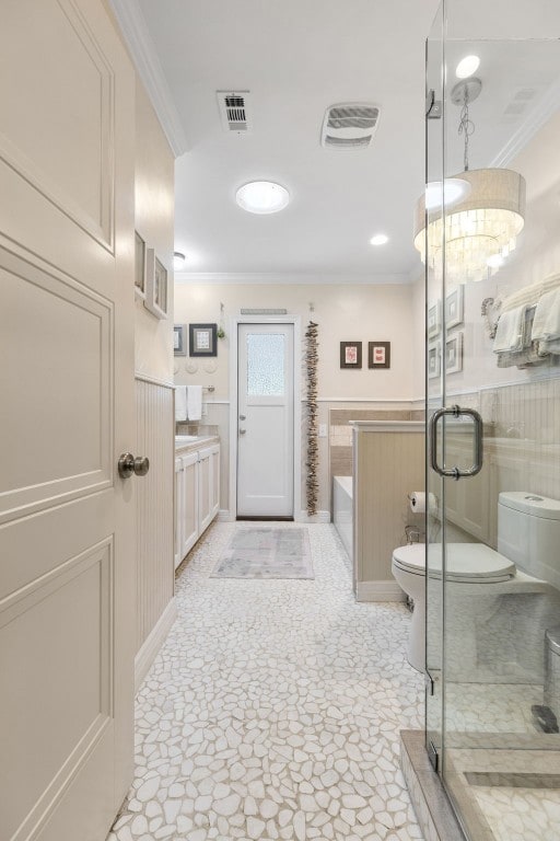 full bathroom featuring toilet, vanity, crown molding, and plus walk in shower