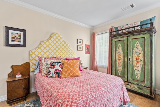 bedroom with wood-type flooring and crown molding