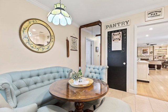 tiled living room with ceiling fan, ornamental molding, and built in shelves