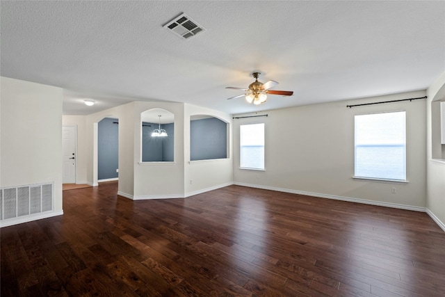 empty room with dark hardwood / wood-style floors, a healthy amount of sunlight, and ceiling fan