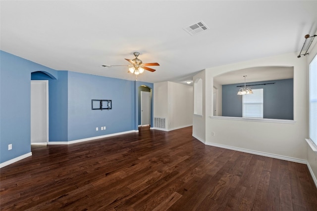 spare room featuring ceiling fan with notable chandelier and dark hardwood / wood-style floors