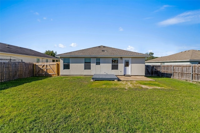 back of house with a patio and a lawn