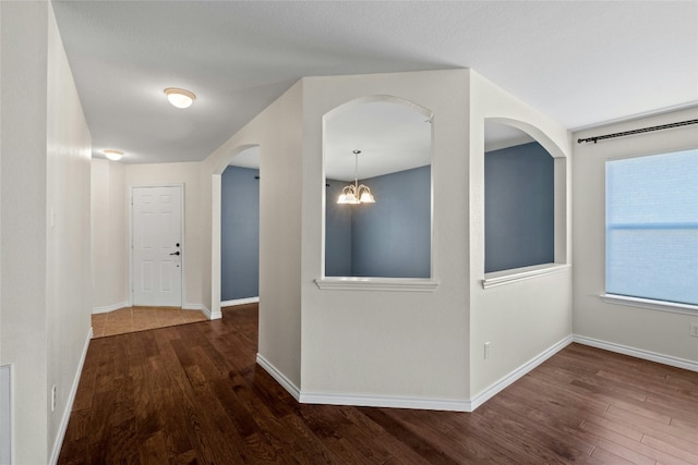 hall featuring a chandelier and dark hardwood / wood-style floors