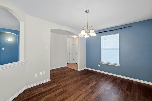 unfurnished room featuring dark wood-type flooring and a chandelier