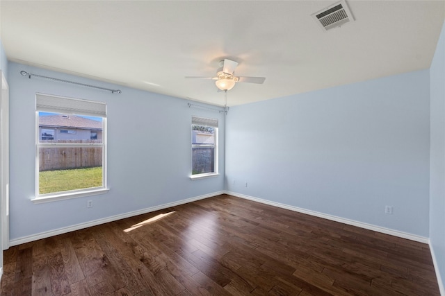 spare room featuring dark hardwood / wood-style floors, a healthy amount of sunlight, and ceiling fan