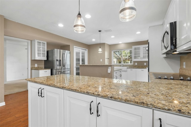 kitchen featuring white cabinets, pendant lighting, and stainless steel appliances