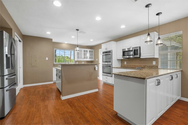 kitchen featuring kitchen peninsula, appliances with stainless steel finishes, white cabinetry, and hanging light fixtures