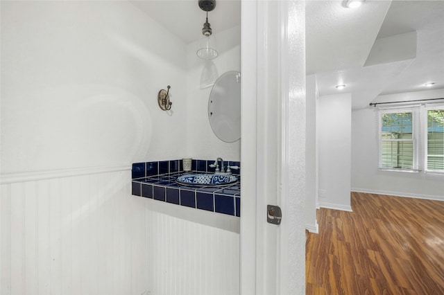 bathroom with wood-type flooring and a textured ceiling