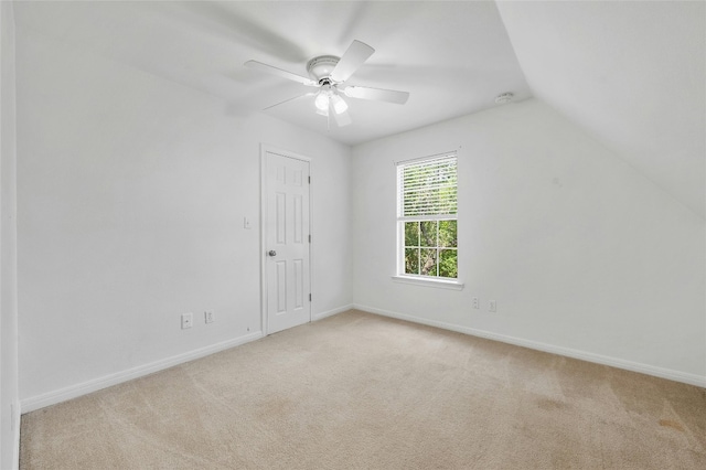 unfurnished room featuring light colored carpet, vaulted ceiling, and ceiling fan