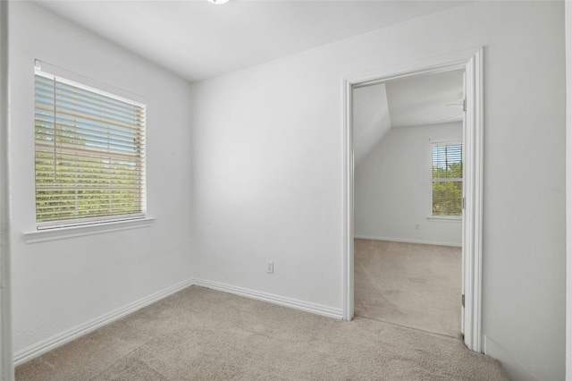 unfurnished room with light carpet and vaulted ceiling