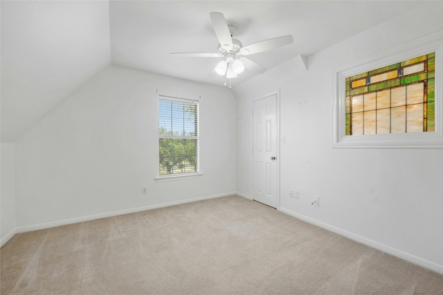 unfurnished room featuring ceiling fan, light carpet, and vaulted ceiling