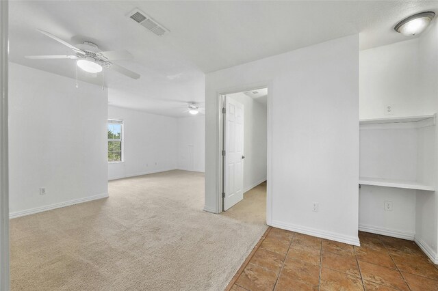 carpeted empty room featuring ceiling fan