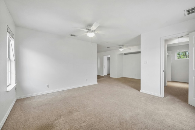 interior space with ceiling fan and light colored carpet