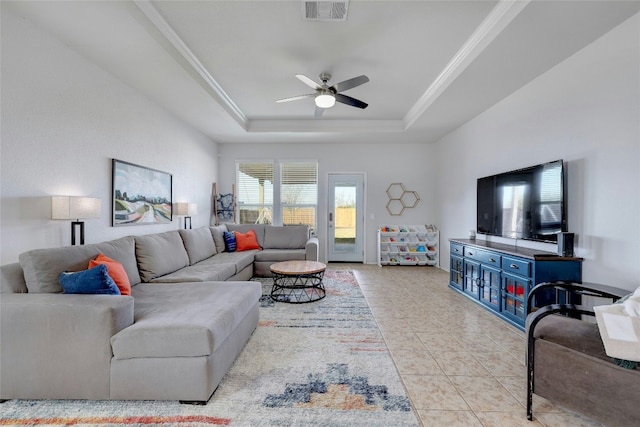 living room featuring a raised ceiling, ceiling fan, and light tile patterned flooring