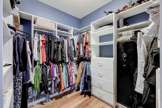 walk in closet with light hardwood / wood-style floors