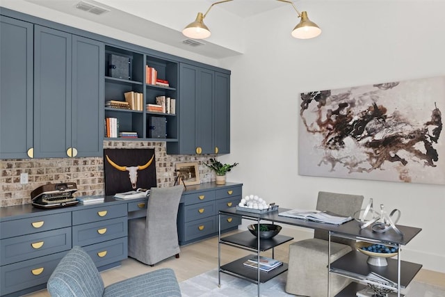 home office with light hardwood / wood-style flooring