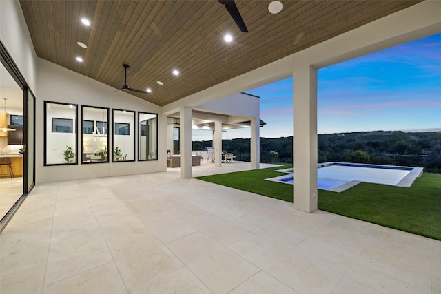 patio terrace at dusk with a lawn and ceiling fan