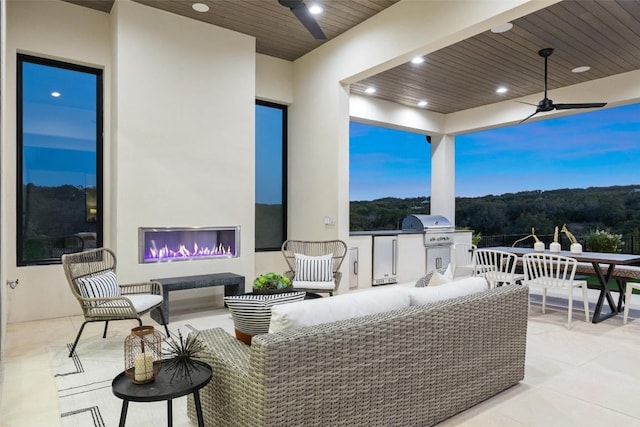 patio terrace at dusk with ceiling fan, a grill, and an outdoor hangout area