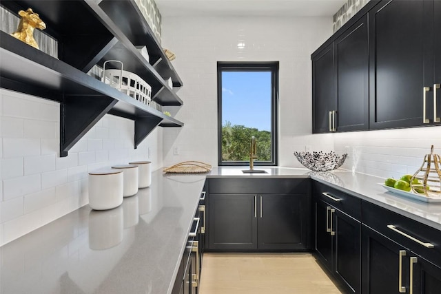 kitchen featuring decorative backsplash, sink, and light hardwood / wood-style flooring