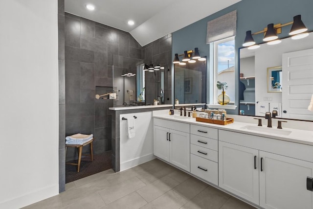 bathroom featuring a shower, tile patterned flooring, vanity, and lofted ceiling