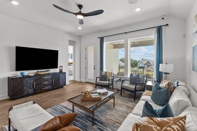 living room featuring hardwood / wood-style flooring, ceiling fan, and vaulted ceiling