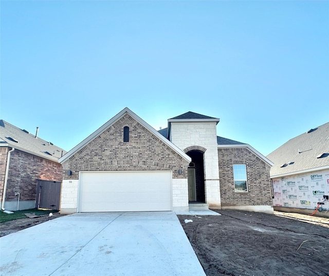 view of front of home with brick siding, driveway, and an attached garage