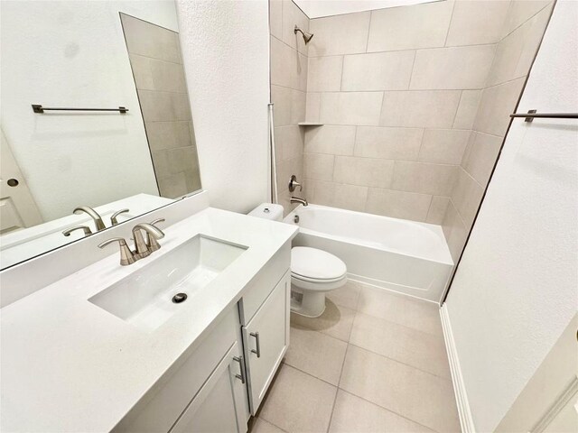 full bathroom with tile patterned floors, tiled shower / bath combo, vanity, and toilet