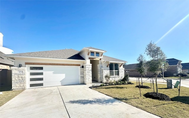 prairie-style home featuring a front yard and a garage