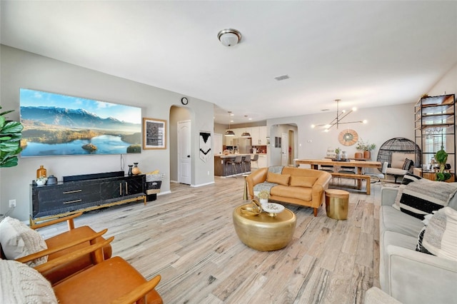 living room featuring an inviting chandelier and light hardwood / wood-style flooring