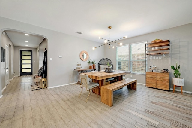 dining space with a chandelier and light hardwood / wood-style floors