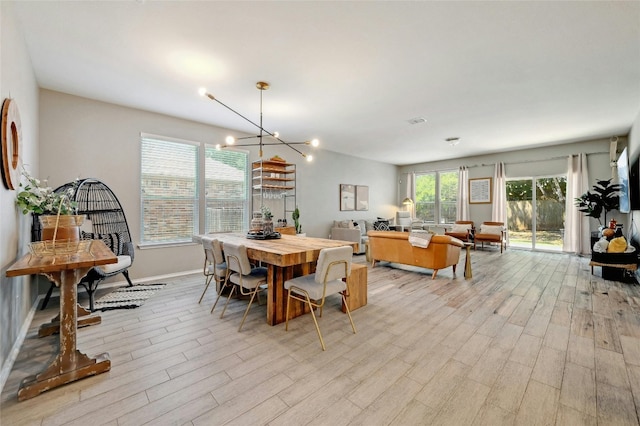 dining space featuring light hardwood / wood-style flooring and a notable chandelier